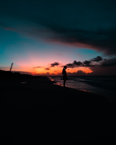 女人站在岸上面临大海在白天
